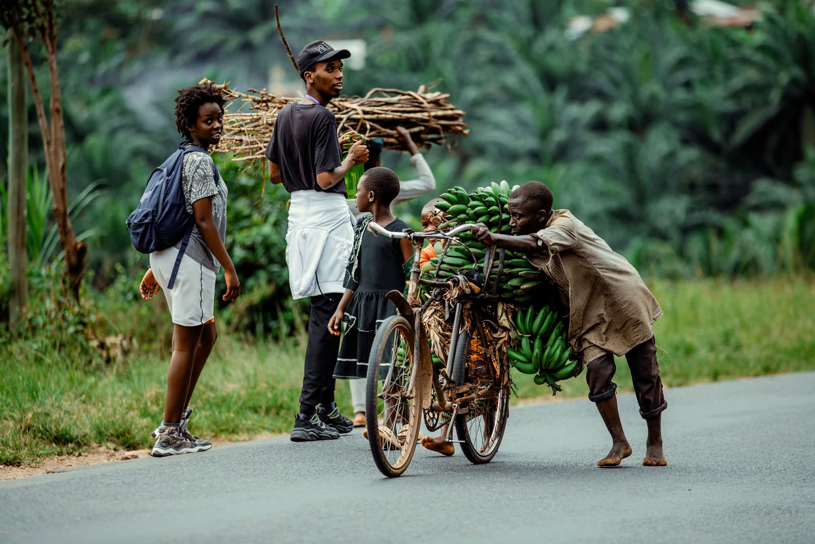 Farmers carrying banana bunches by bicycle on a Rwandan road