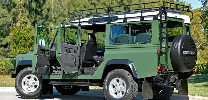 Green open-sided Land Rover Defender safari vehicle