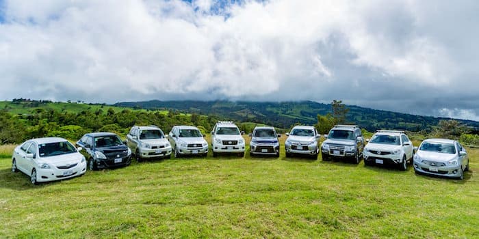 Rental vehicles parked in a row on a lawn in Rwanda